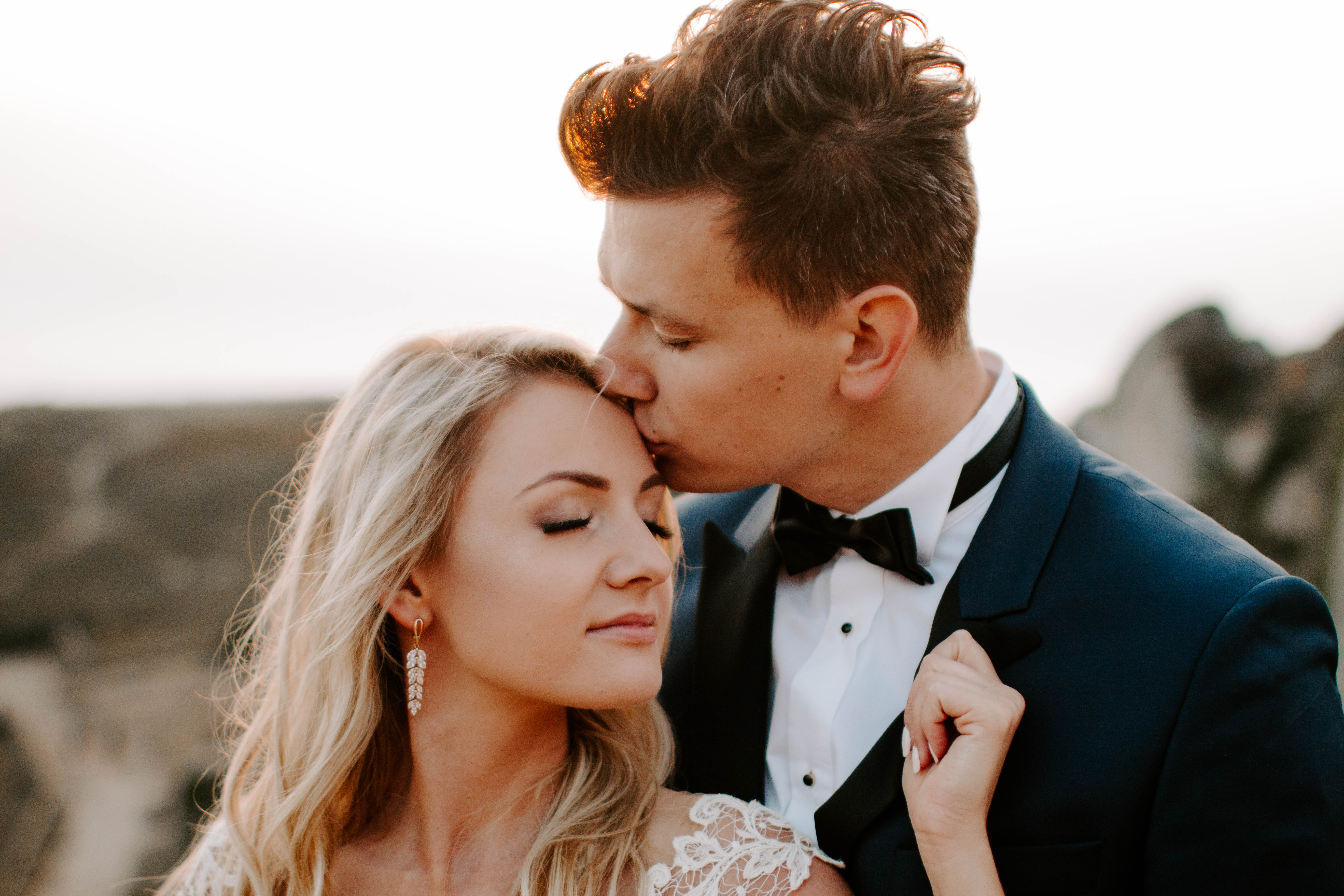 groom kissing bride on forehead