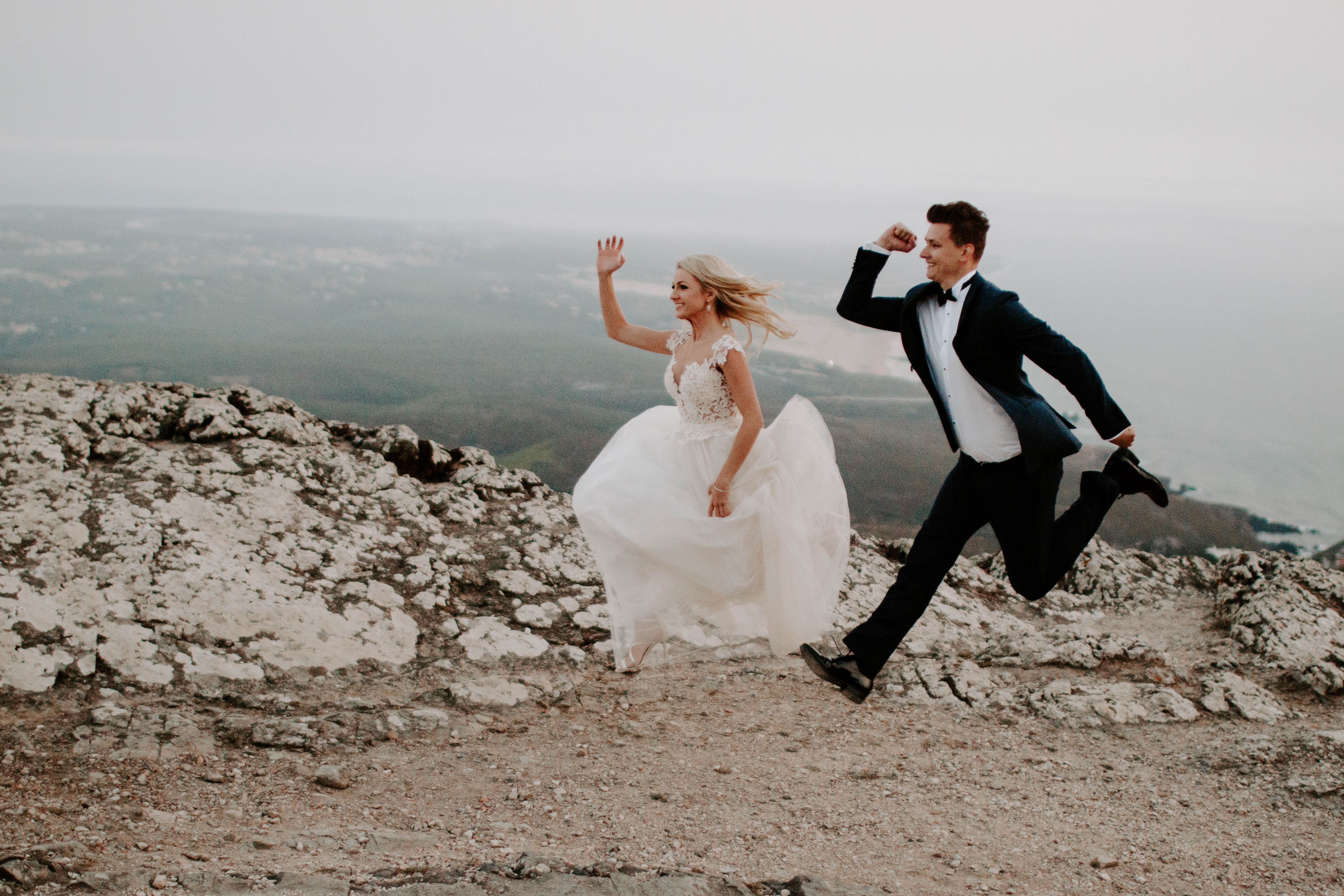 playful bride and groom photo jumping