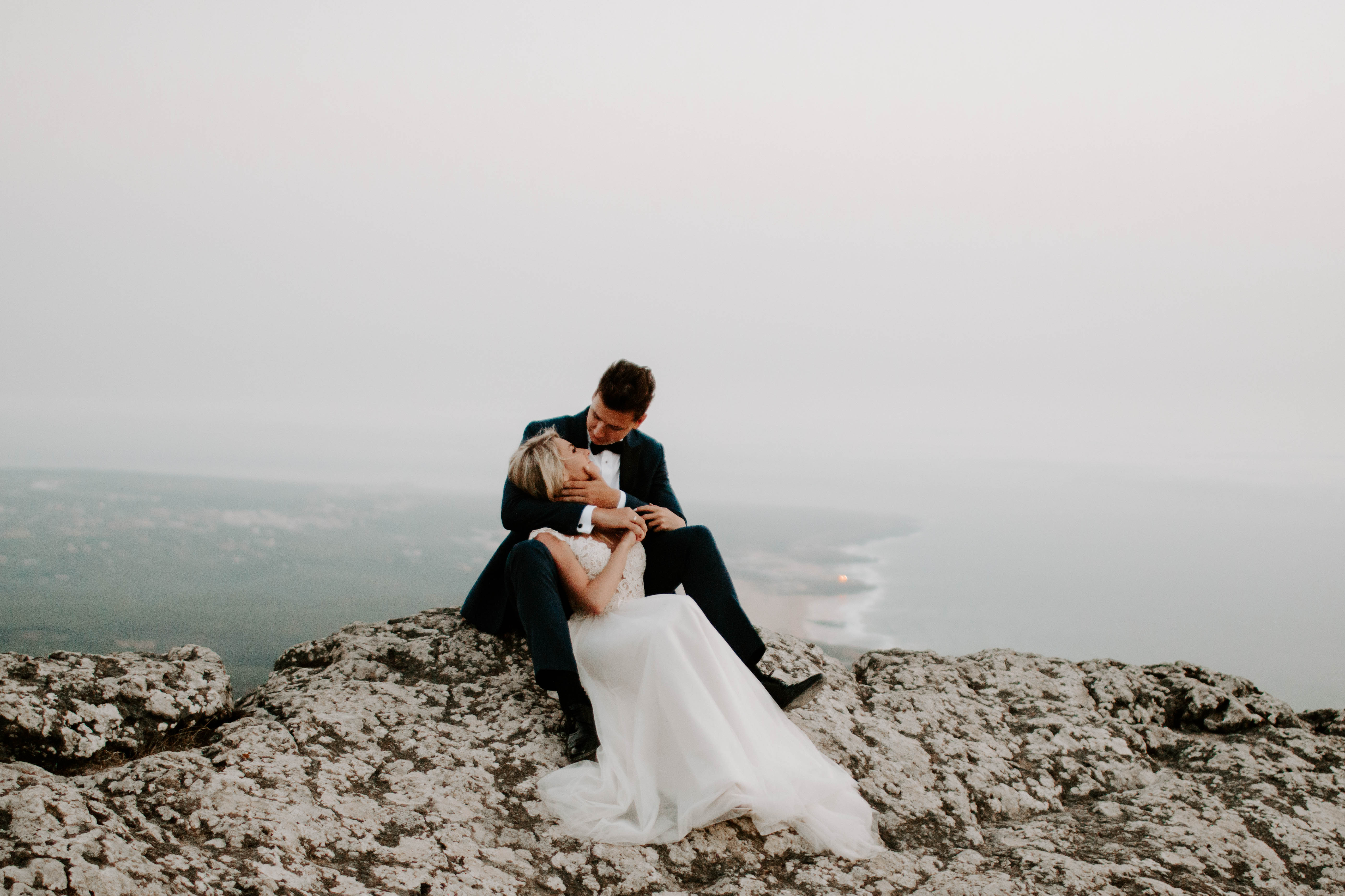 just married couple posing on a cliff with beach view, wedding photography in melbourne
