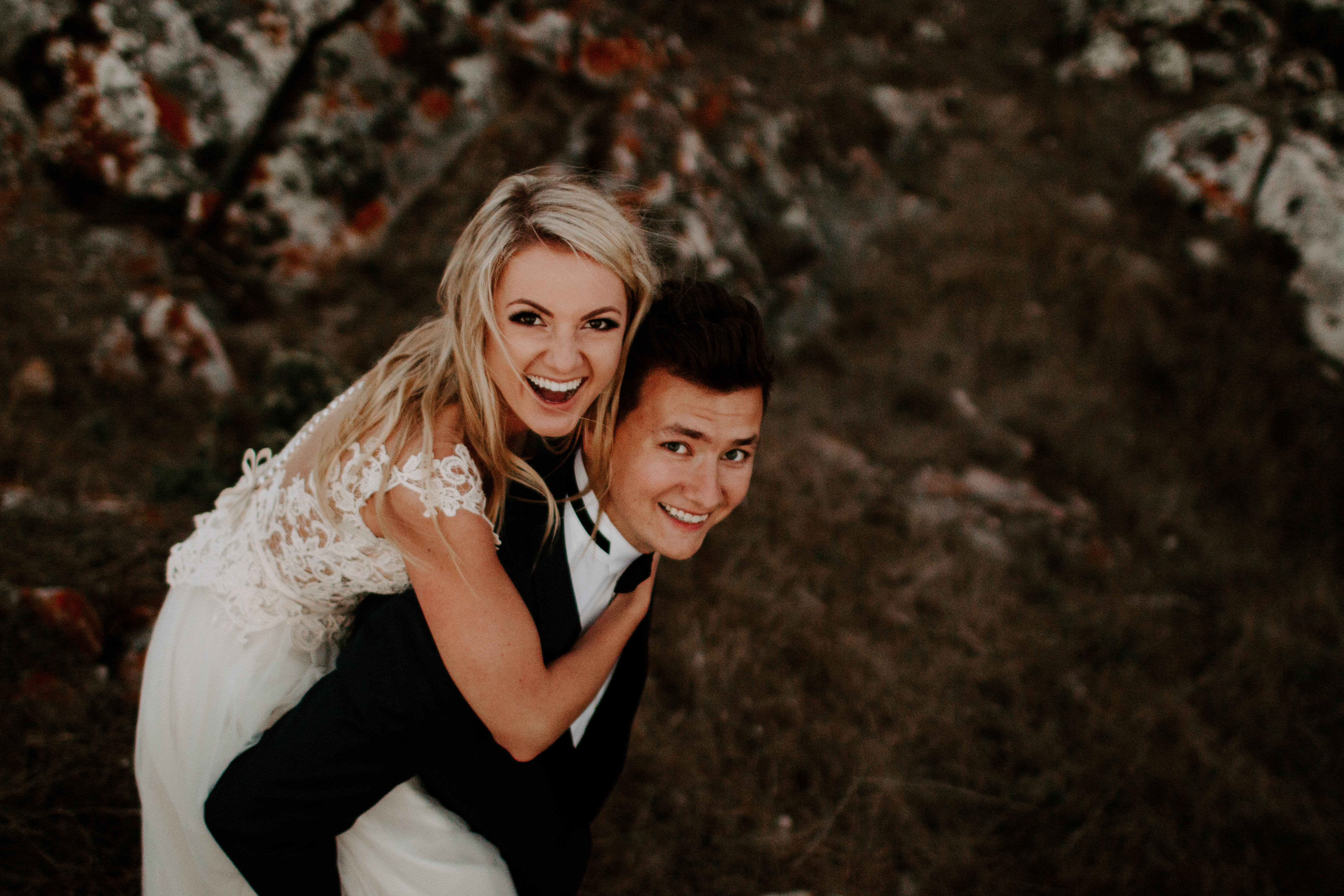 bride riding piggyback on groom