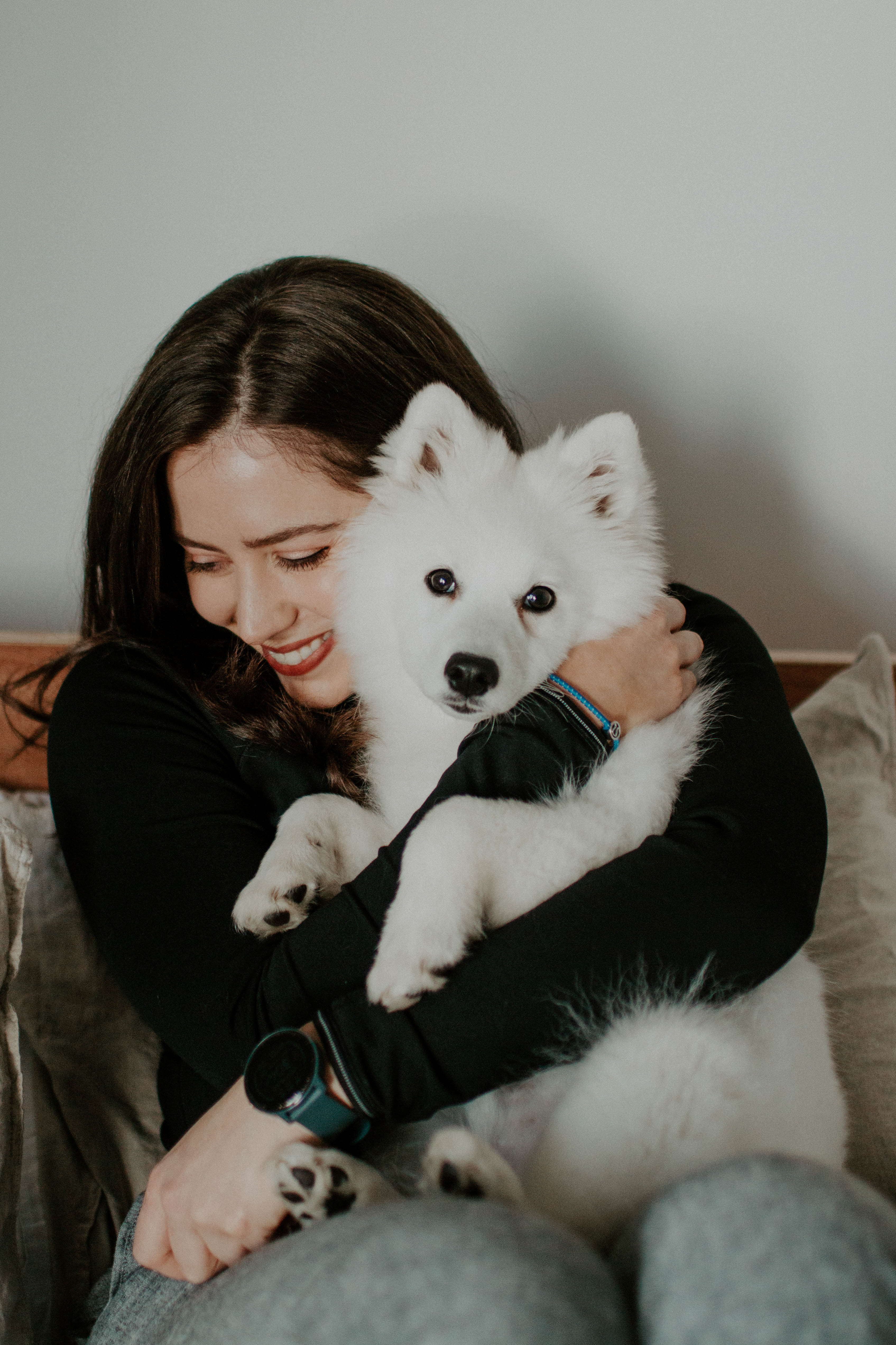 girl with a white puppy on a sofa