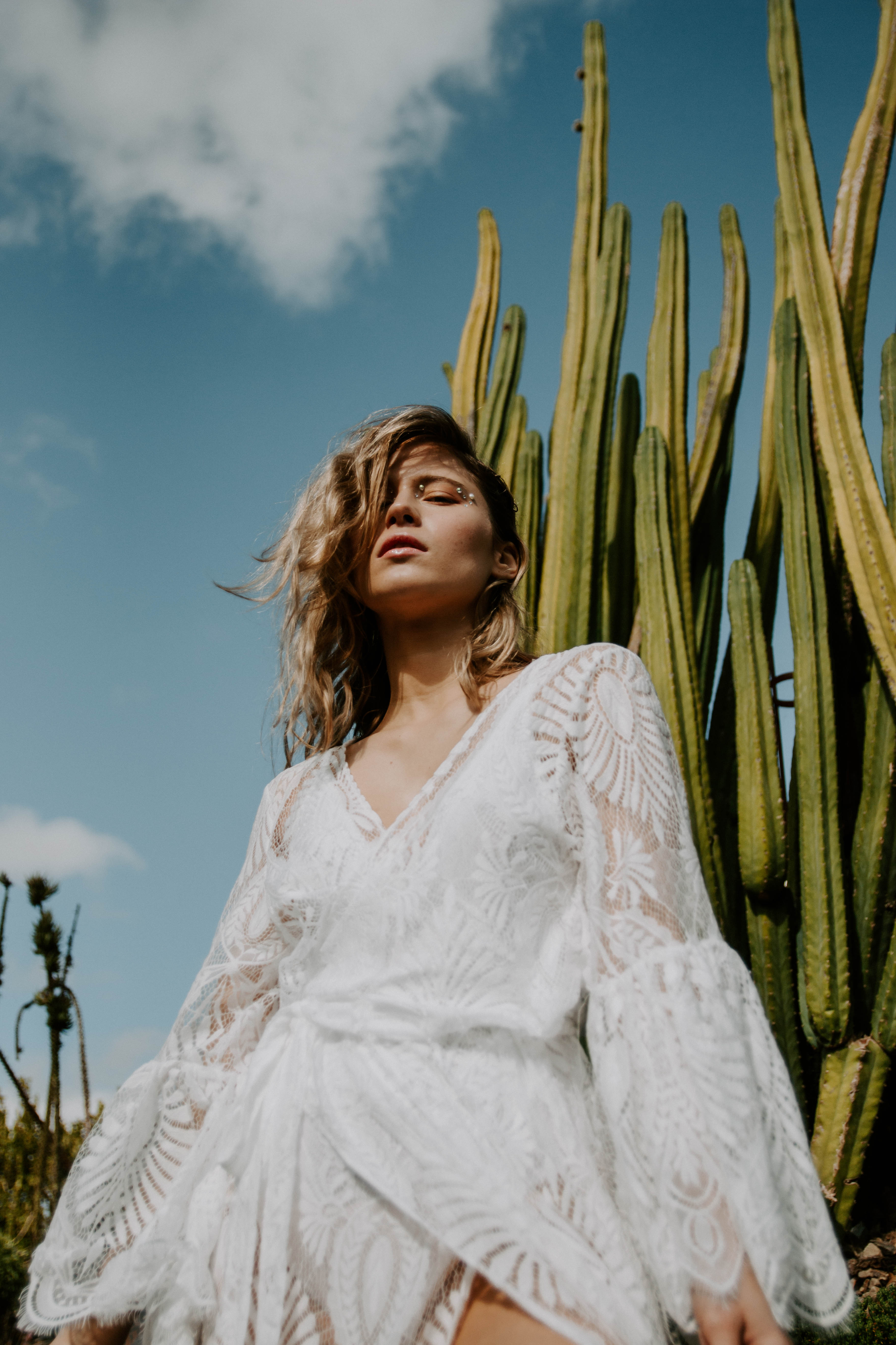 blonde model wearing lace dress posing in botanical garden