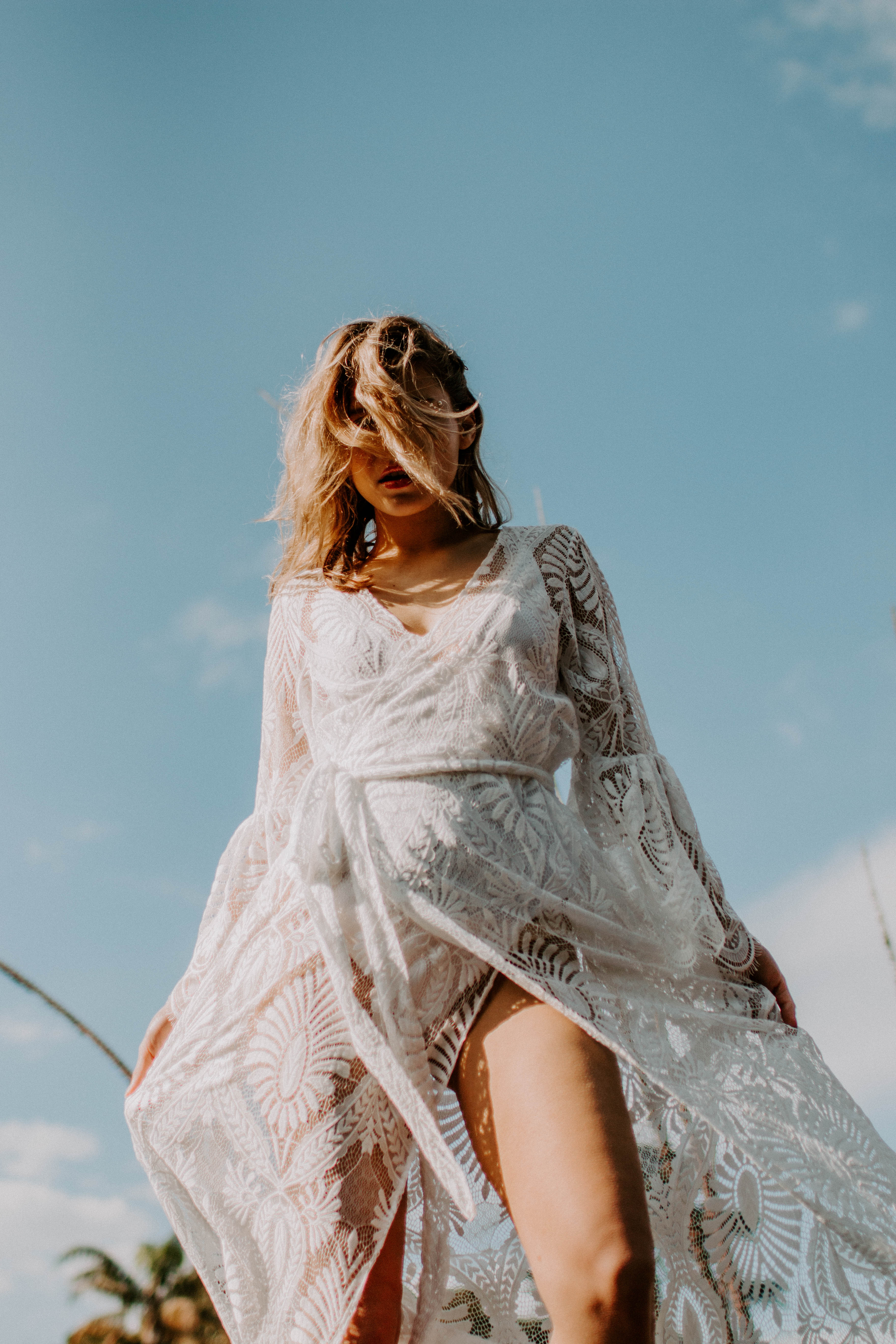 model posing on a rock with white lace wedding dress