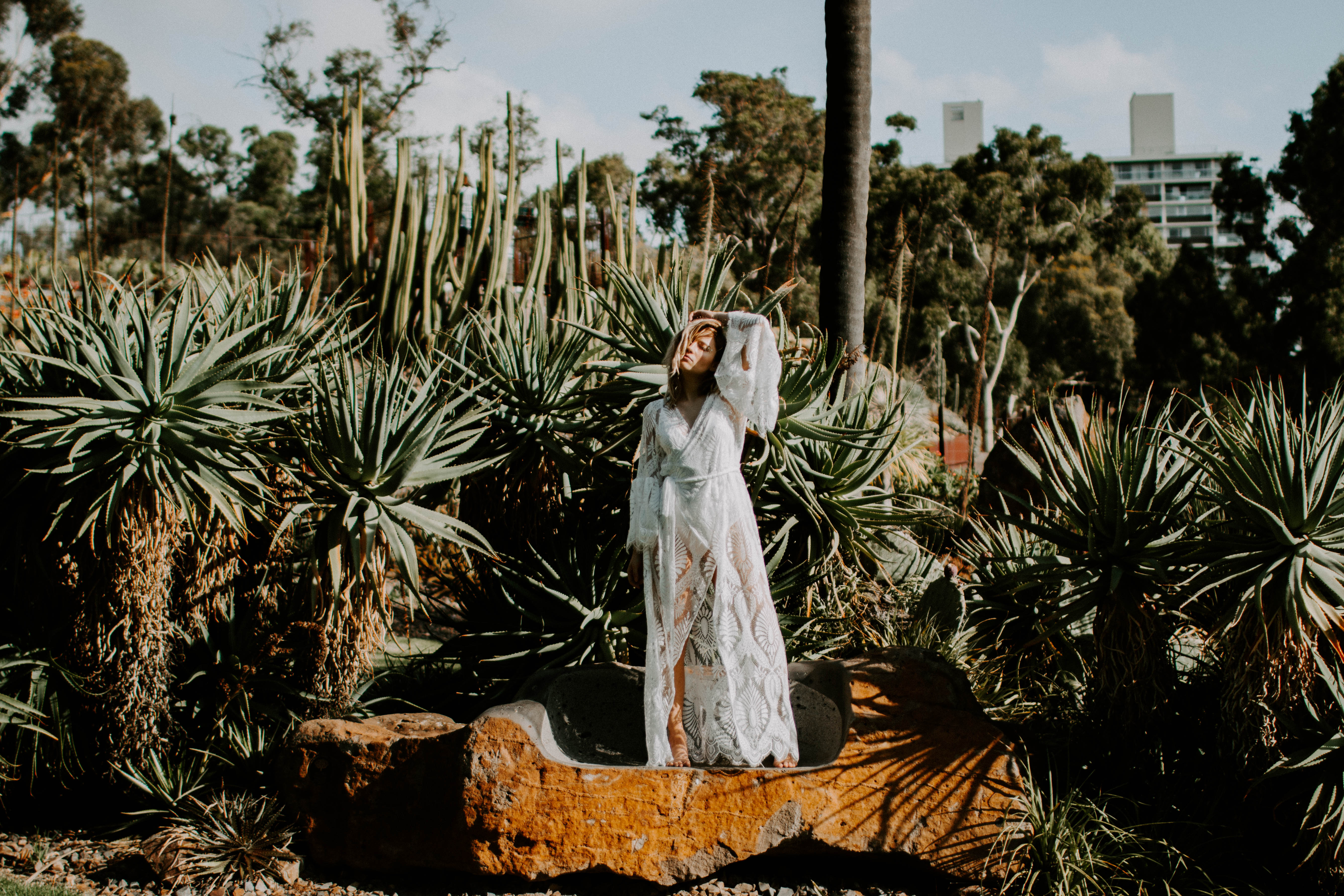 beautiful girl standing on a rock wearing bohemian lace dress
